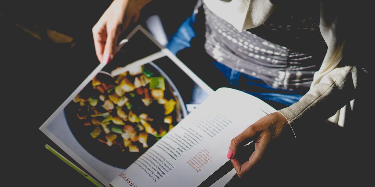 A woman flips through a recipe book