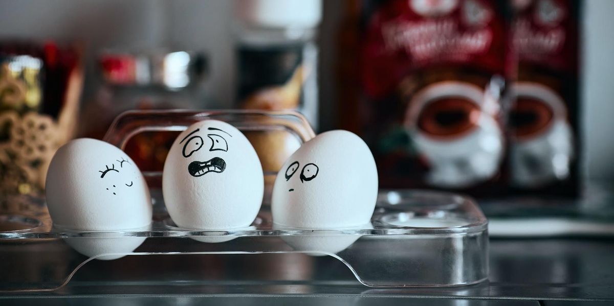 Three eggs with drawn faces face one another, one smiles, one is scared, the other slightly shocked