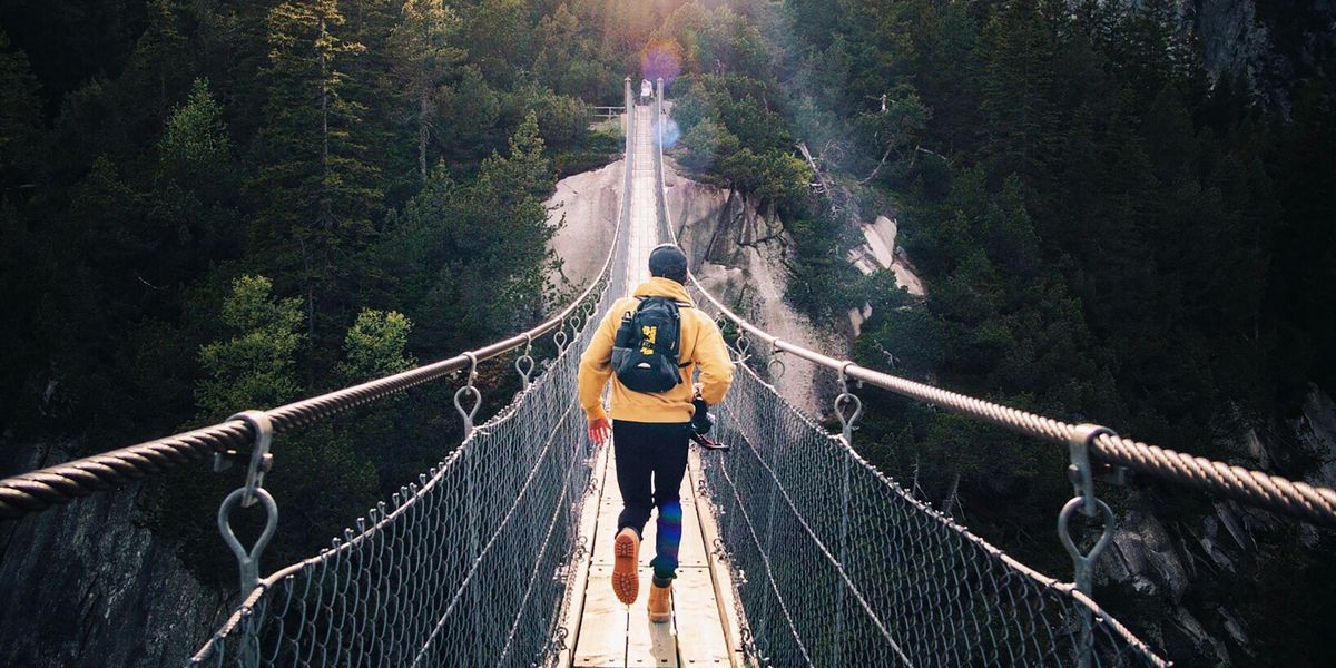 Man running across suspended walking bridge