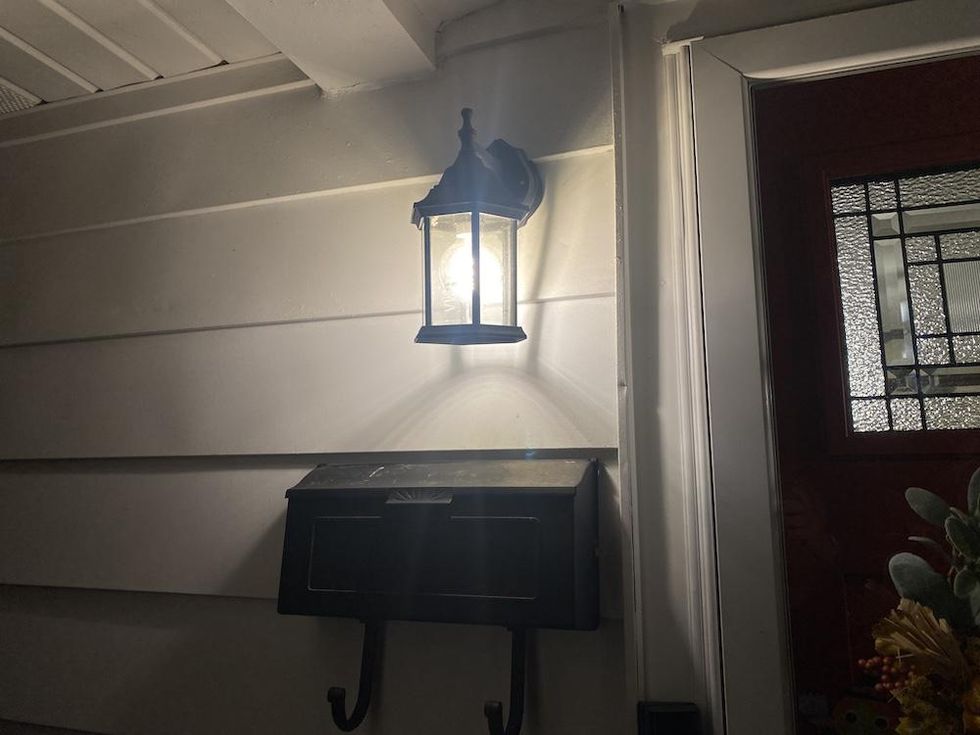 a photo of the outside of a house and sconce with Cync Direct Connect Smart Bulb inside
