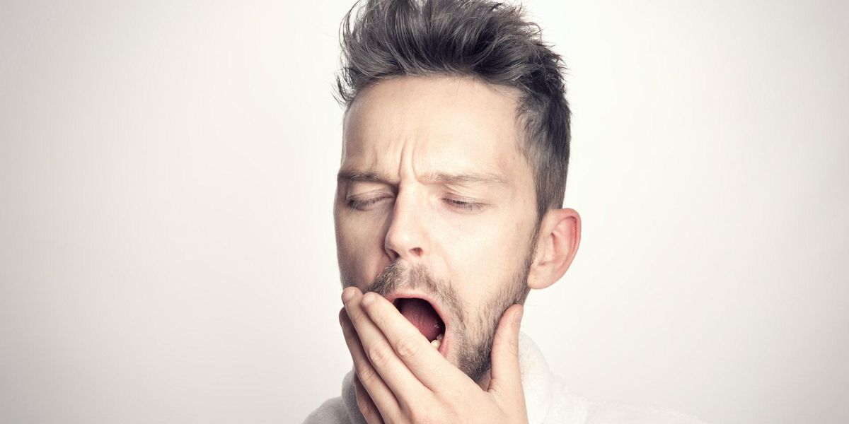 A young guy is yawning
