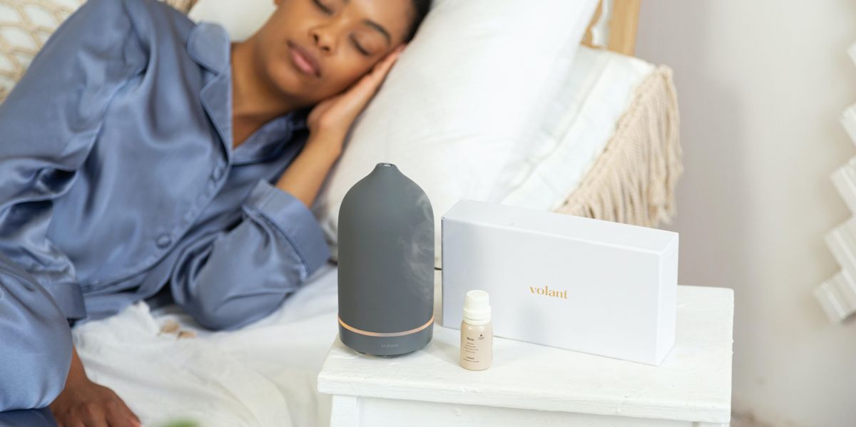 Woman comfortably sleeping with diffuser and essential oils