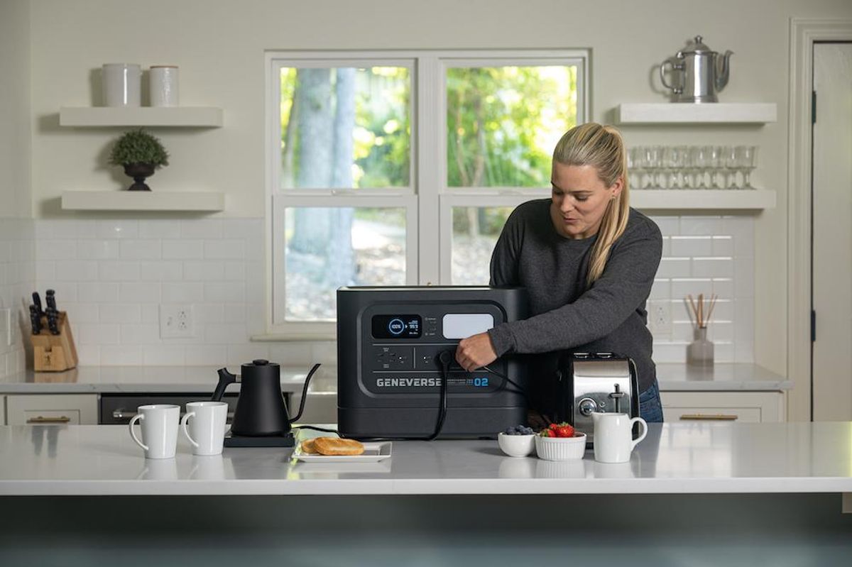 a photo of a woman using Geneverse Solar powered generator in her kitchen