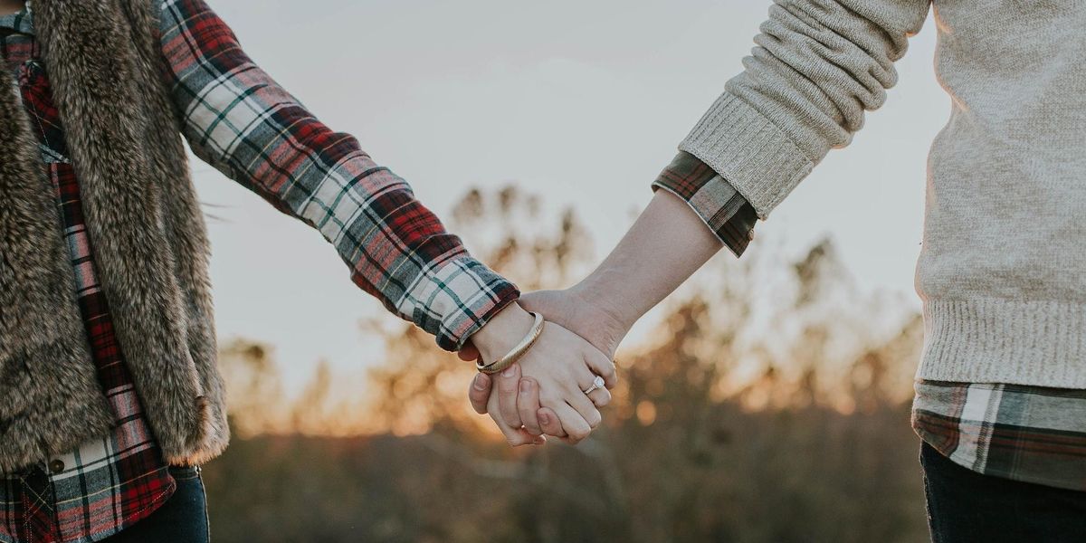 A couple hold hands