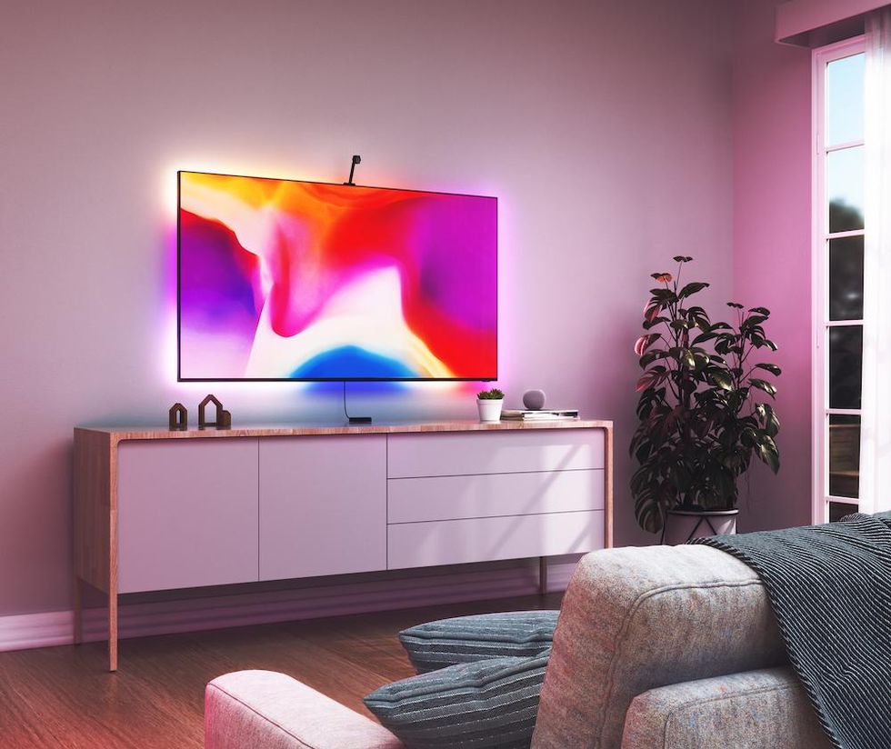 a smart tv on the wall with Nanoleaf tv backlight strips