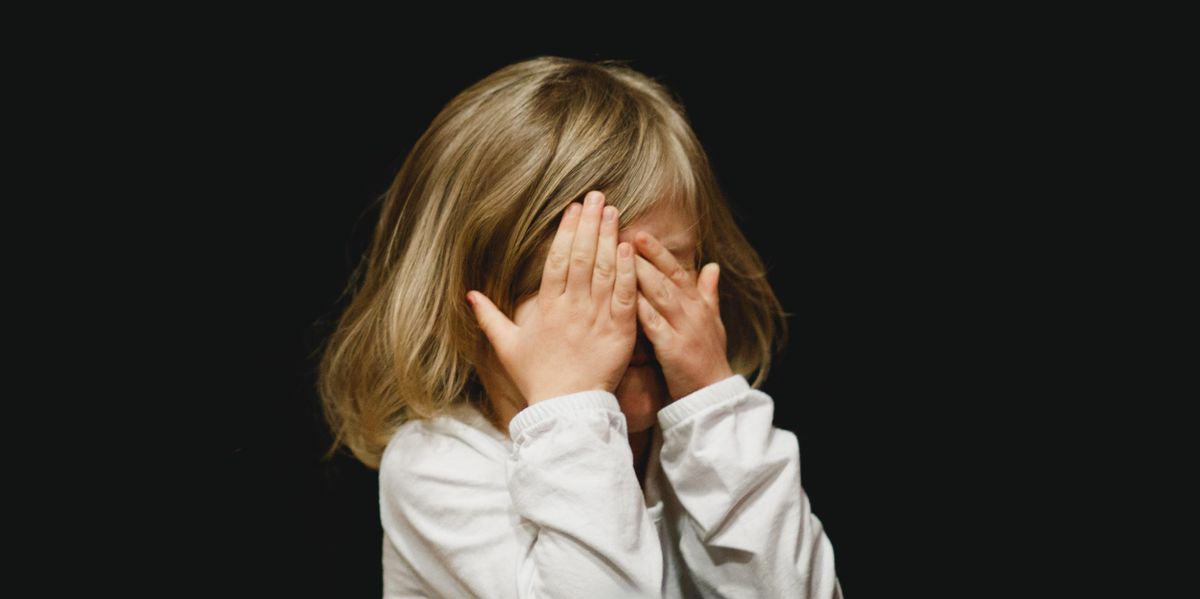 Little girl covering her face