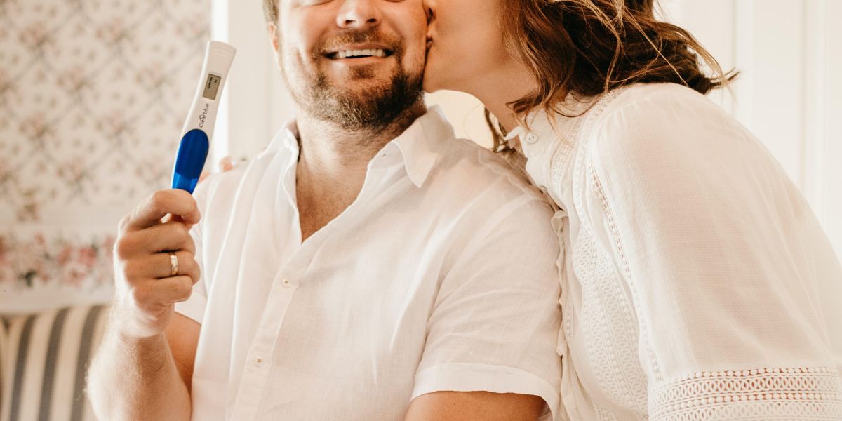 Man and woman holding positive pregnancy test