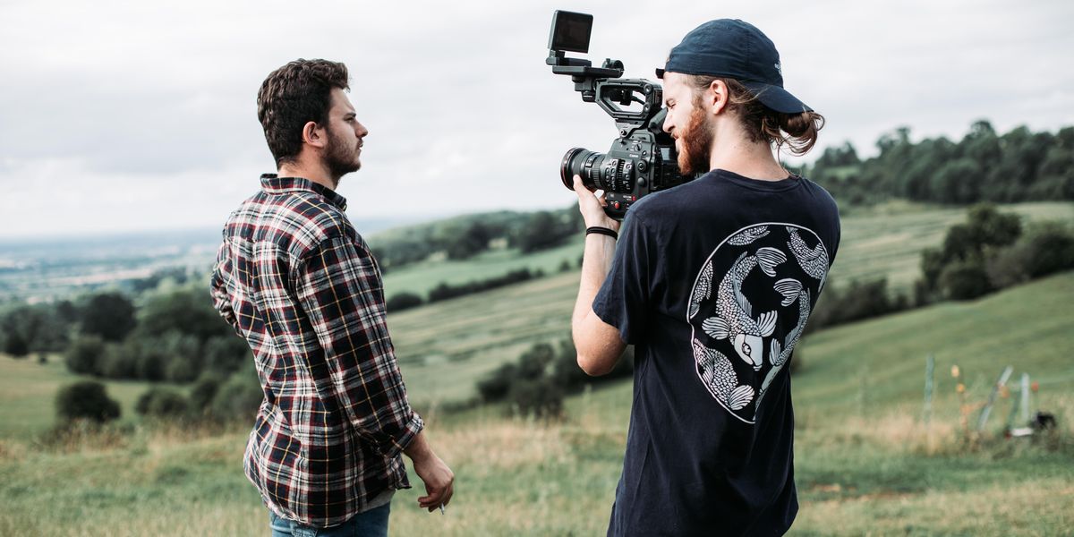 man in black and white crew neck t-shirt holding black video camera