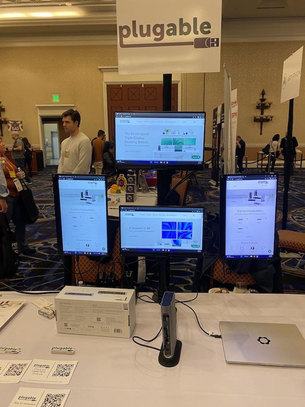 Photo of Plugable demonstrating how to connect 4 monitors from one docking station
