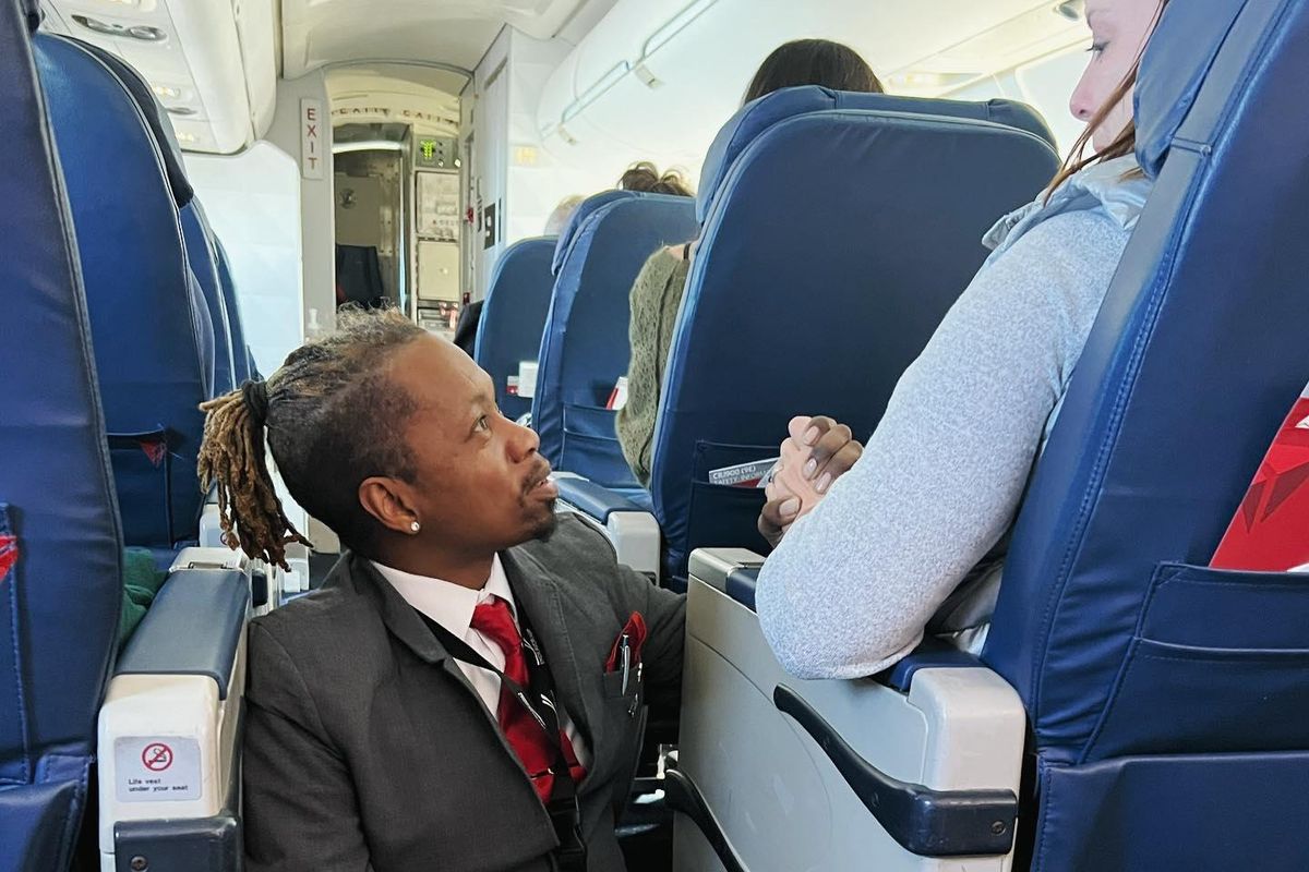 Flight attendant sits on the floor to comfort passenger - Upworthy