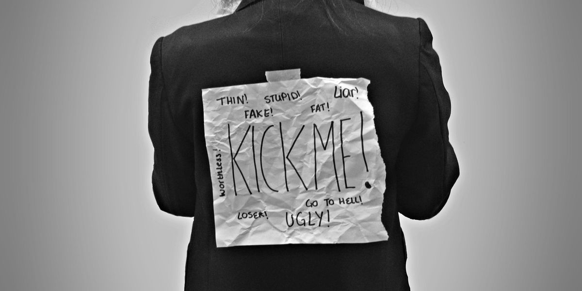 Person with kick-me sign on their back