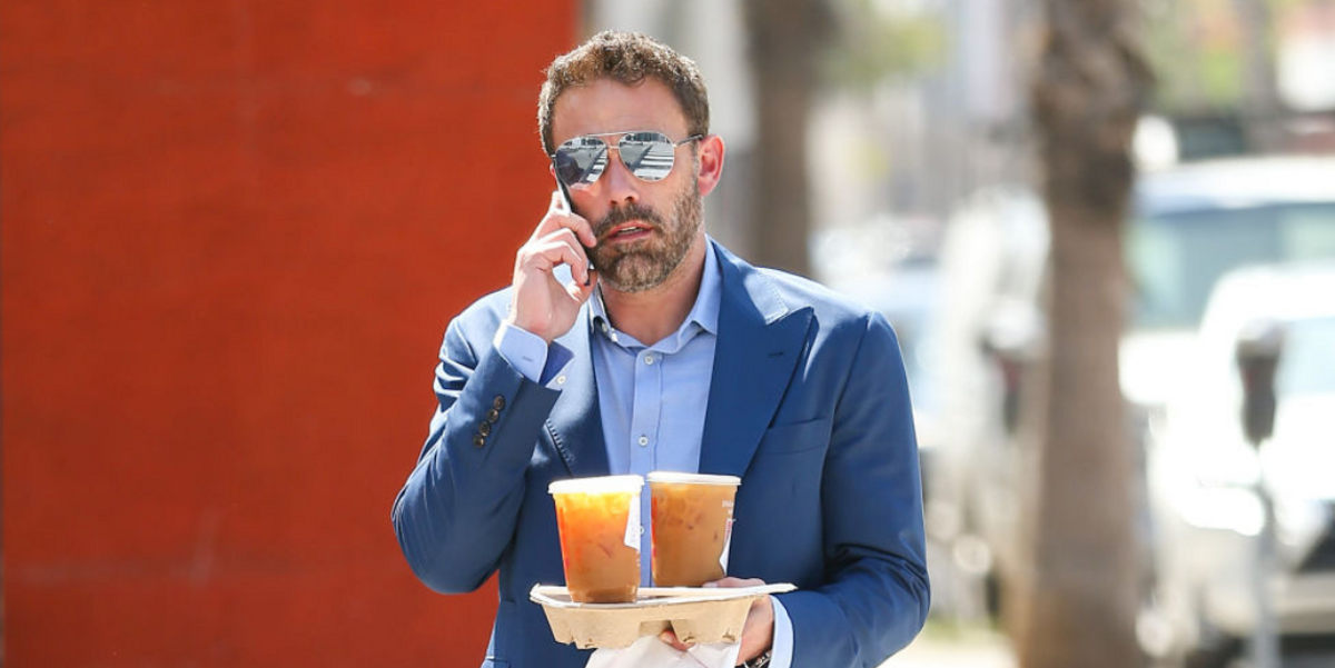Ben Affleck on cell phone and holding Dunkin Donuts coffee