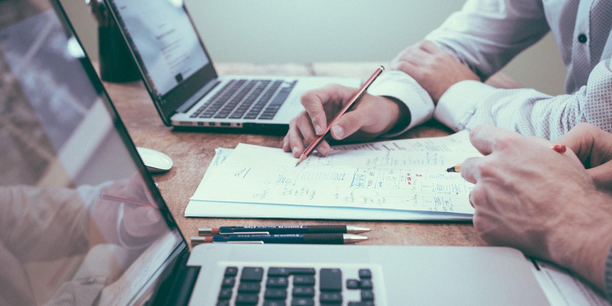 Two people working on solutions on paper