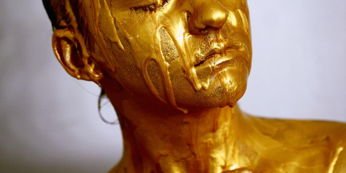 Woman covered in gold poster paint