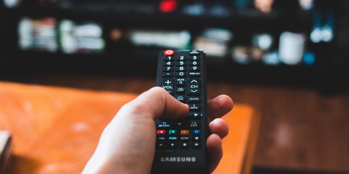 Person aiming remote control at the TV