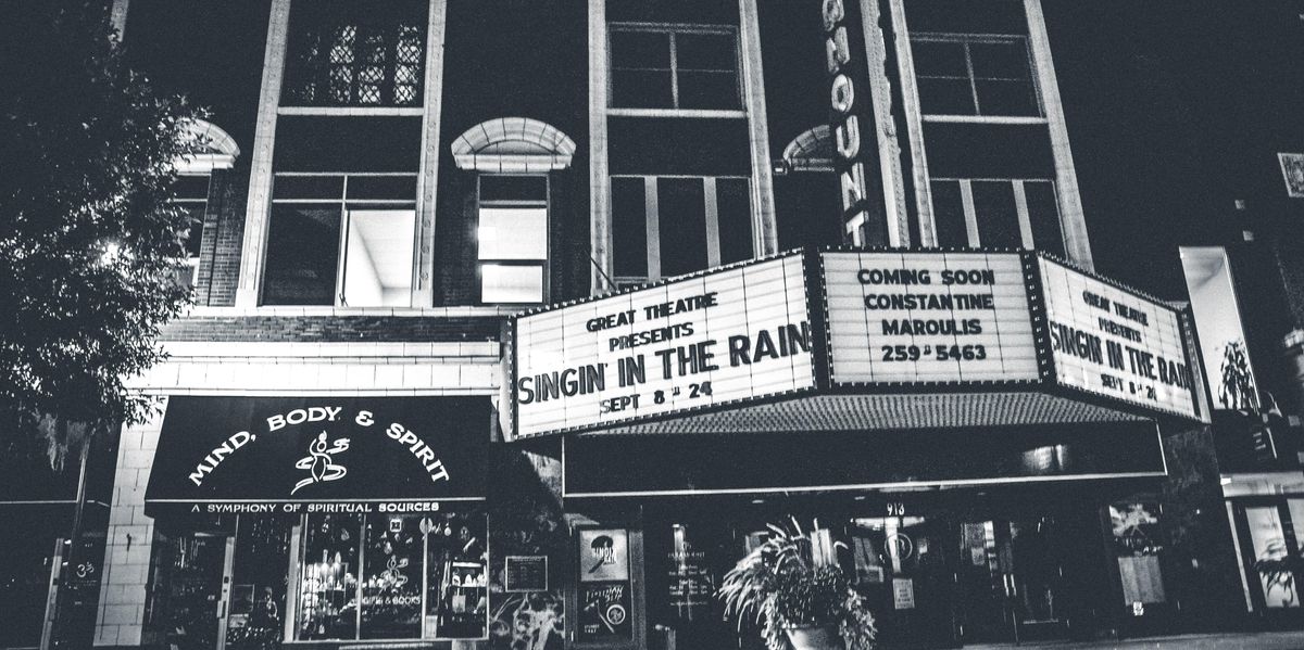Black and white photo of a movie theater showing "Singing in the Rain"