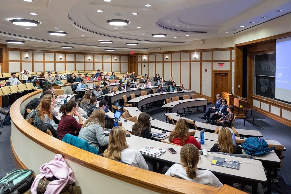 Dozens of students listen to guest speakers in a University Classroom