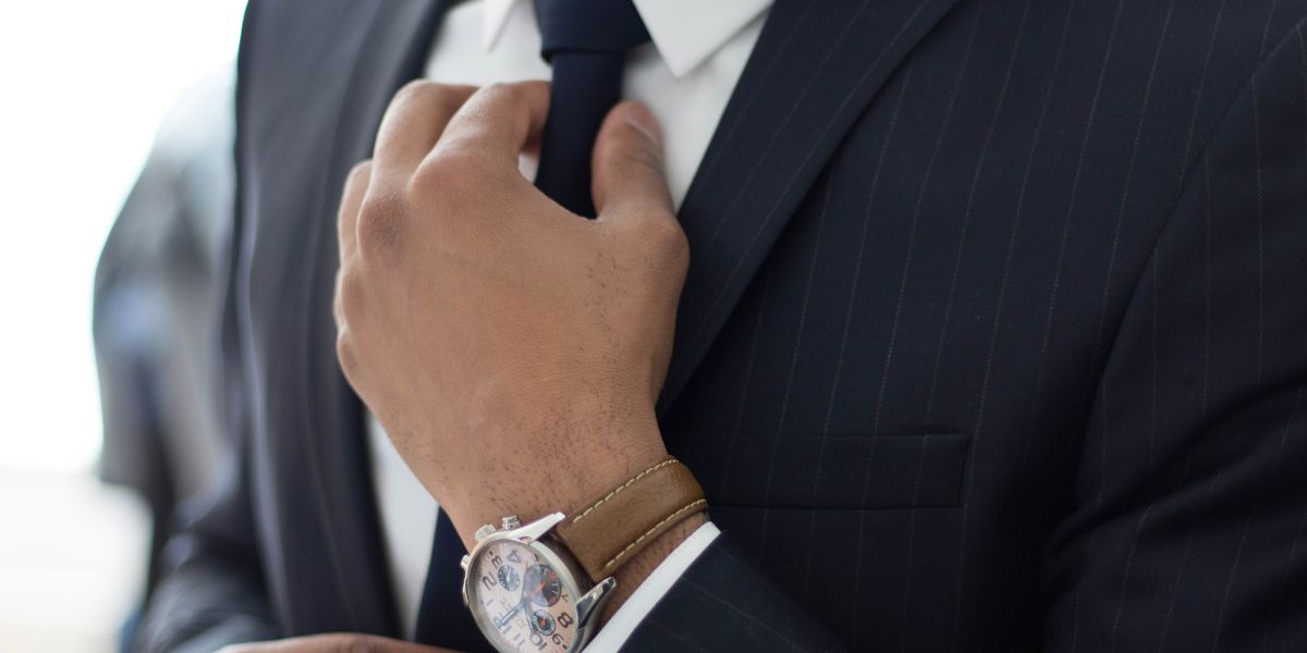 Man in suit fixing tie