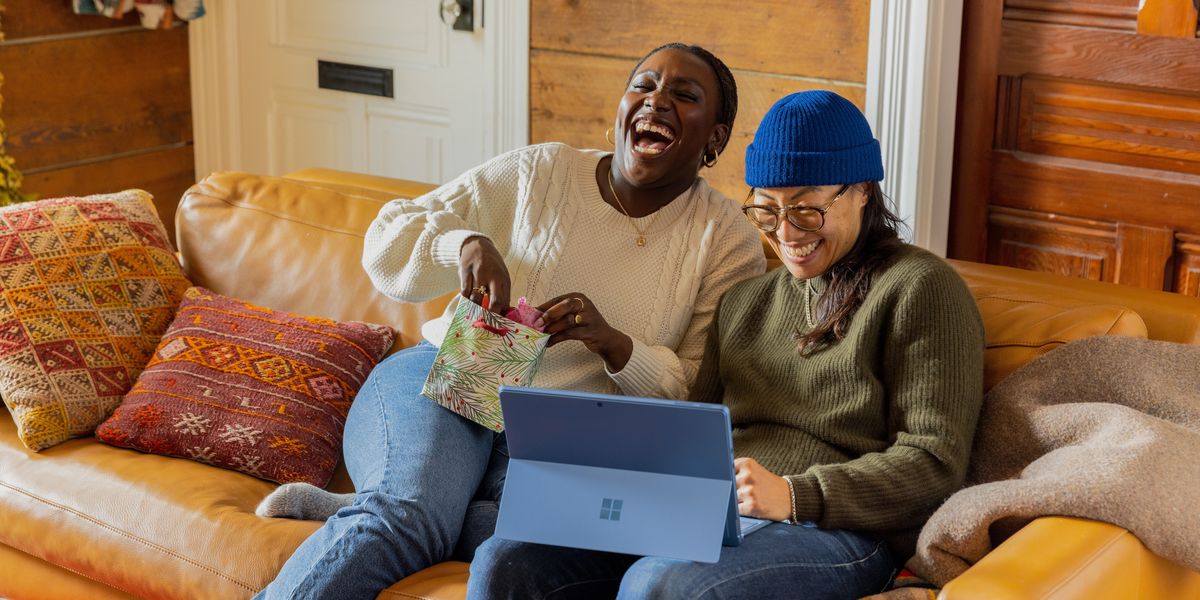 Two women laughing at something on a computer