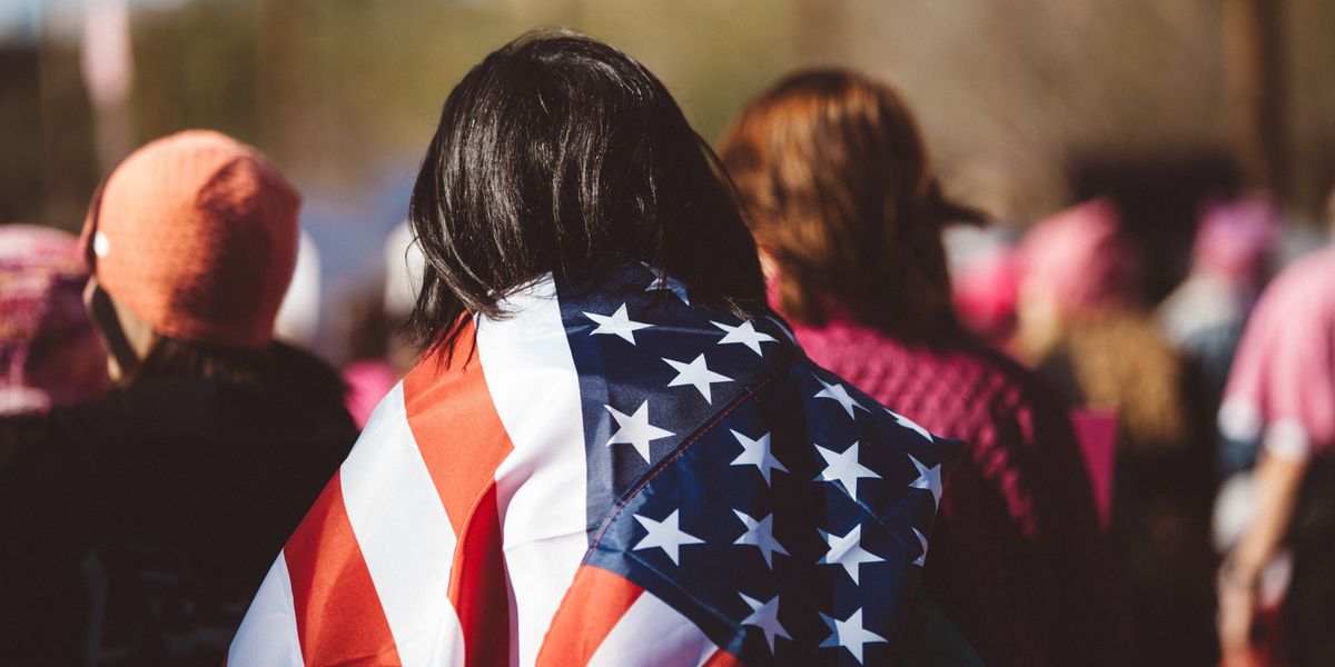Woman with American flag wrapped around her shoulders