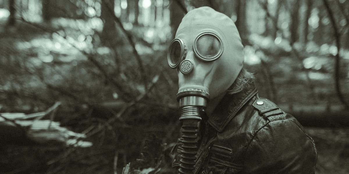 grayscale photo of person wearing gas mask and leather jacket