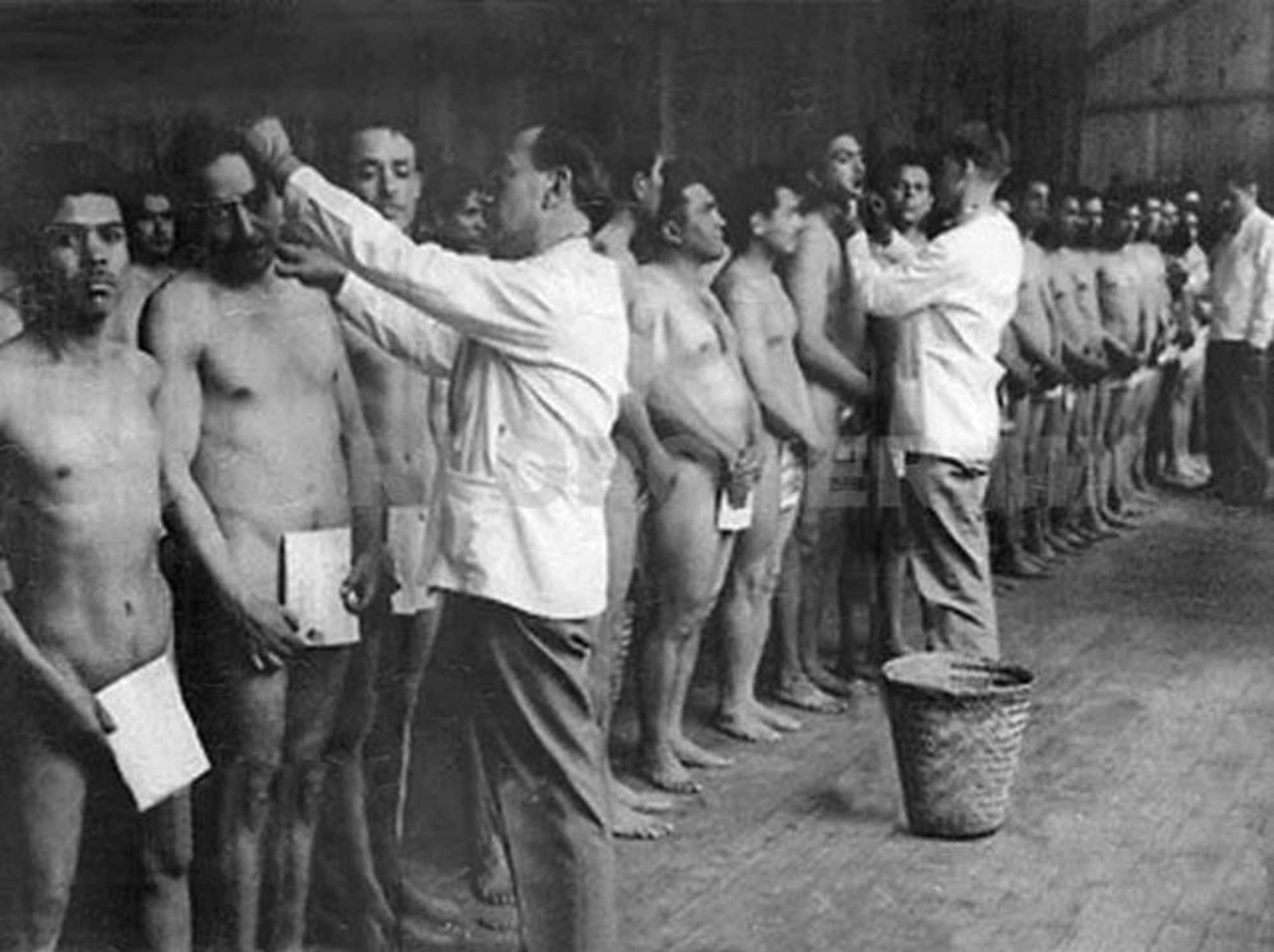 Mexican male workers in the Bracero Program being doused with chemicals while undergoing a routine sanitization.