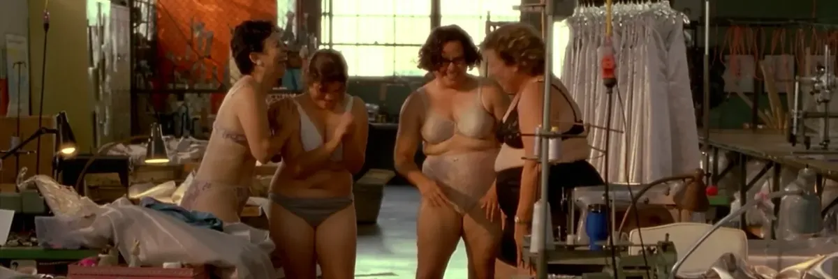 Still image from the film Real Women Have Curves / Las Mujeres de Verdad Tienen Curvas (2002) directed by Patricia Cardoso showing four women in their underwear laughing with each other