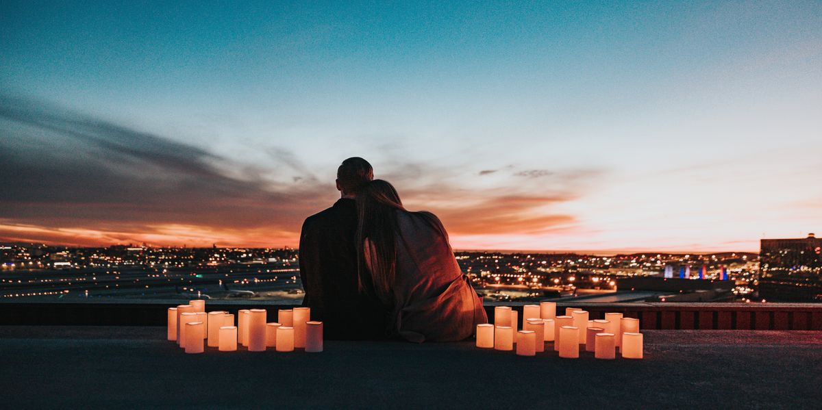 Couple on roof with candles, overlooking city