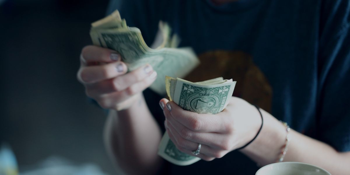 focus photography of person counting dollar banknotes