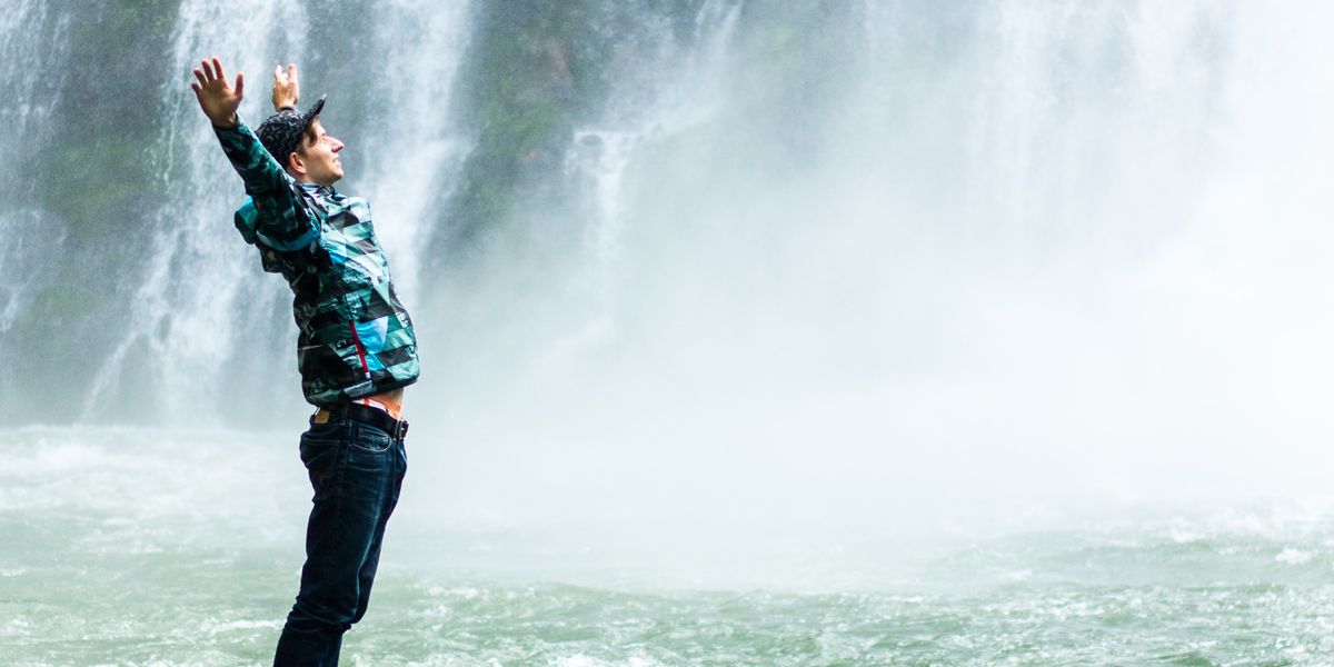 Man standing in front of waterfalls