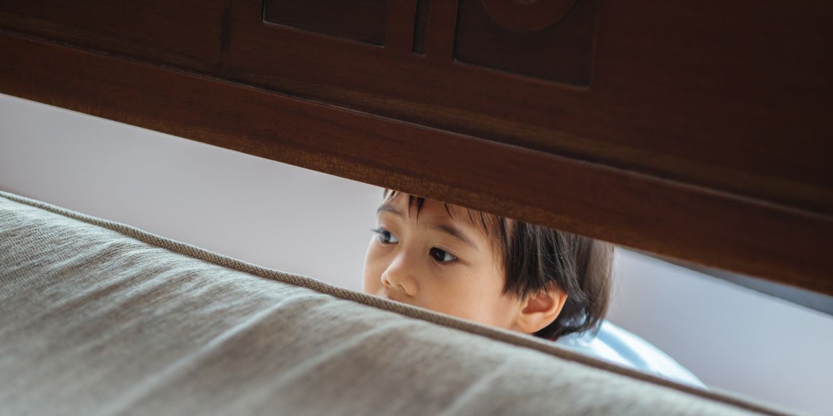 Little boy peeking through a crack