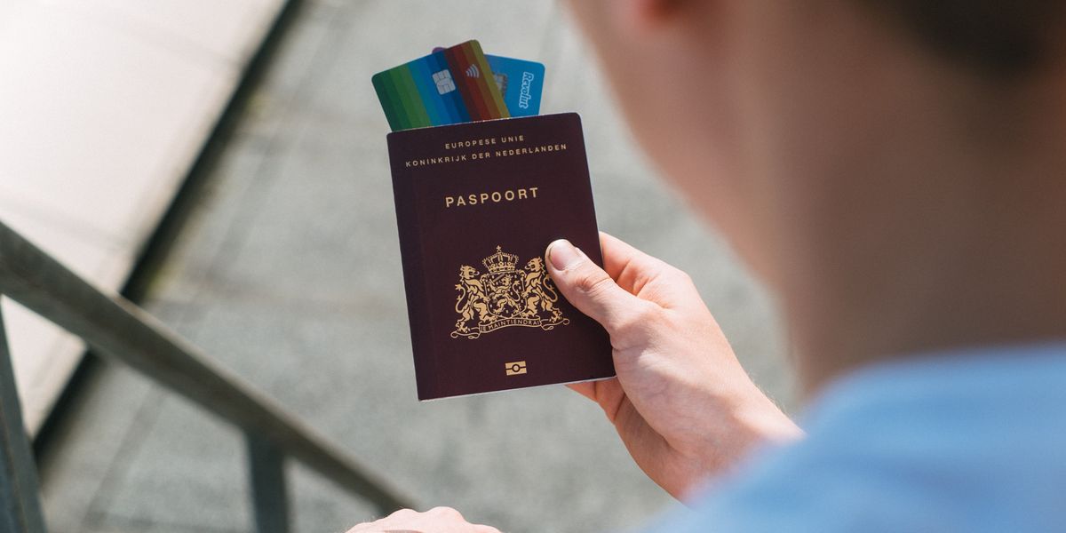 Person holding passport and credit cards