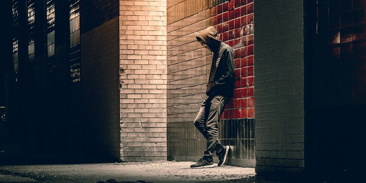 Sad young man in alleyway