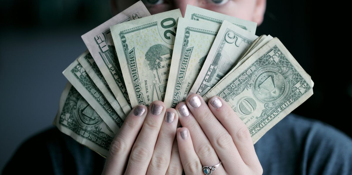 person holding fan of U.S. dollars banknote