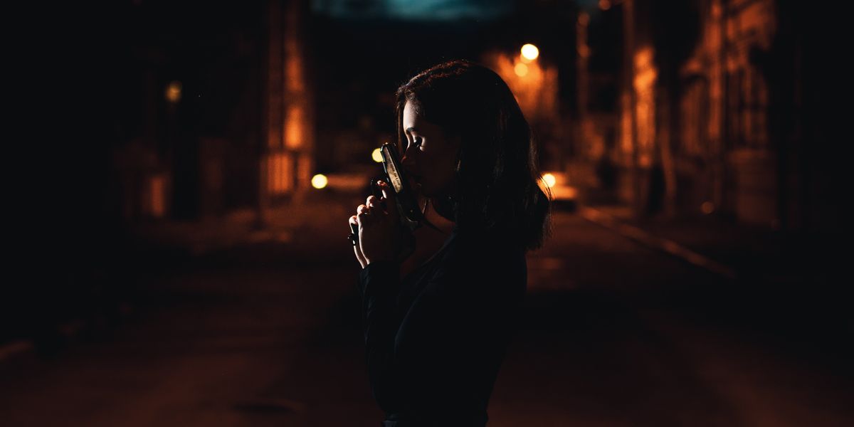 Woman holding a gun in the dark