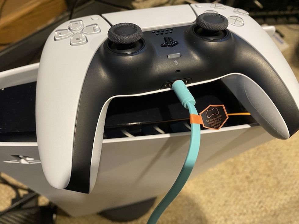 a photo of connecting 3.5 mm aux cable into the PS5 controllers