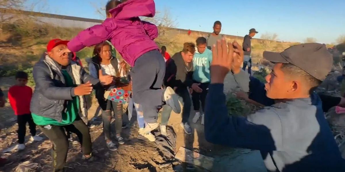 NextImg:Migrants throw babies over river into US, rush border after more online rumors claim they’ll be allowed entry