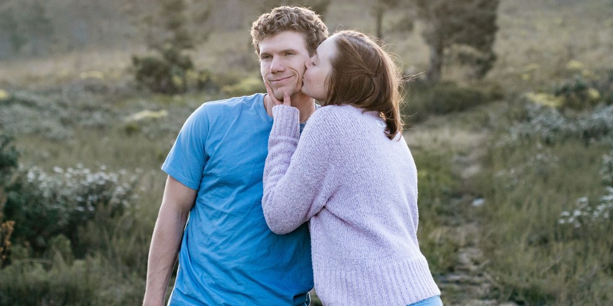 man in blue crew neck t-shirt hugging woman in white long sleeve shirt