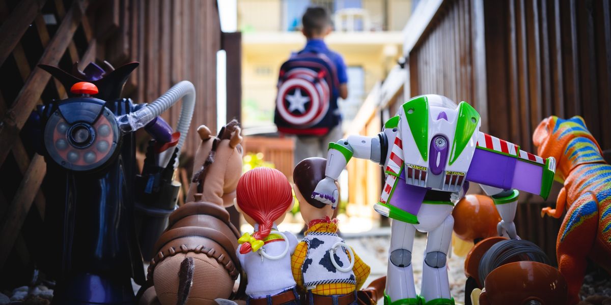 "Toy Story" action figures observe a boy wearing a Captain America backpack.