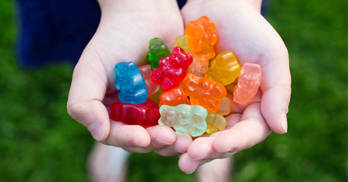 child holding two handfuls of gummy bears