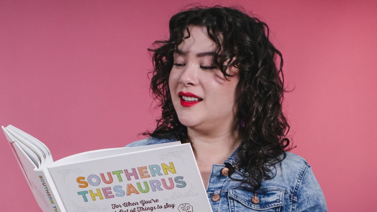 Talia Lin holds a copy of the Southern Thesaurus in front of a pink backdrop.