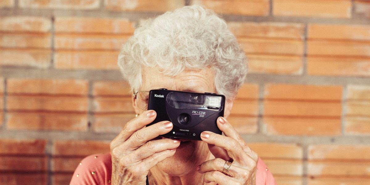 Elderly woman holding Kodak film camera