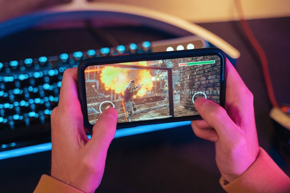 a photo of a smartphone with a person playing a video game
