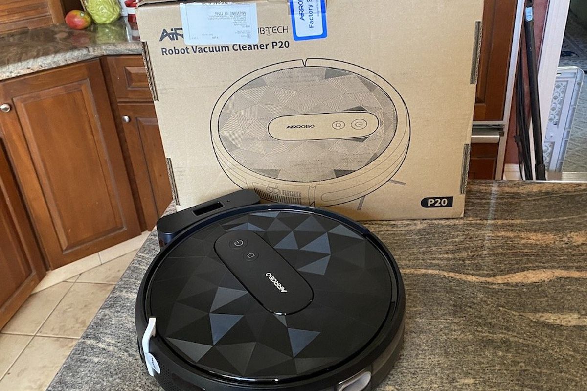 A photo of Airrobo P20 Robot Vacuum and its box on a countertop
