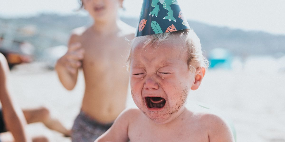 Toddler crying at beach birthday party