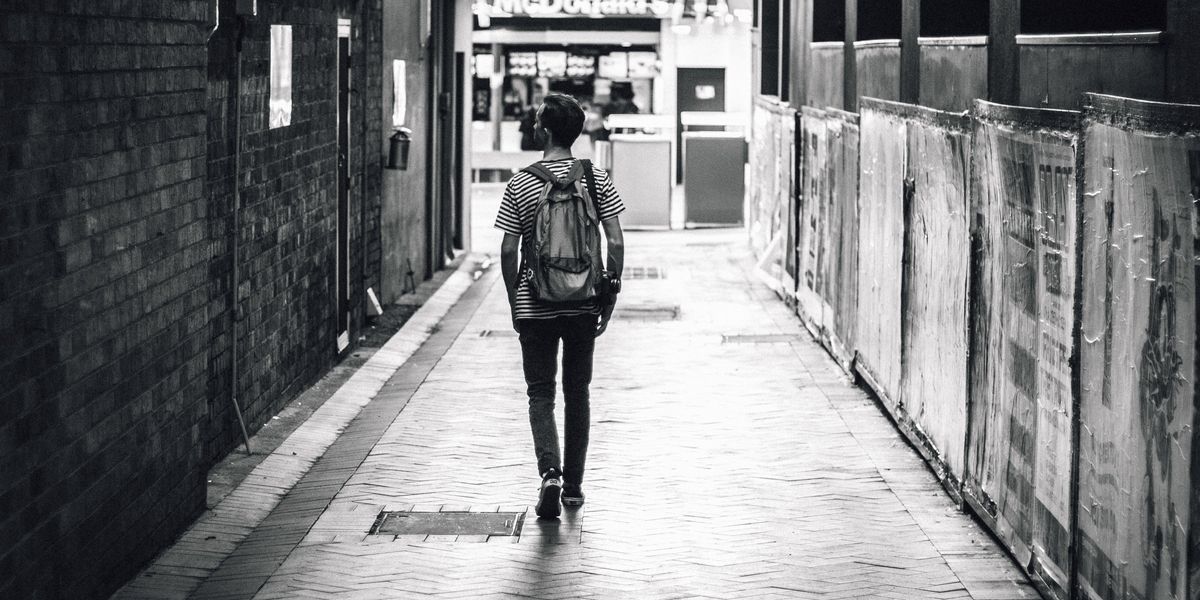 Man walking down alleyway in city