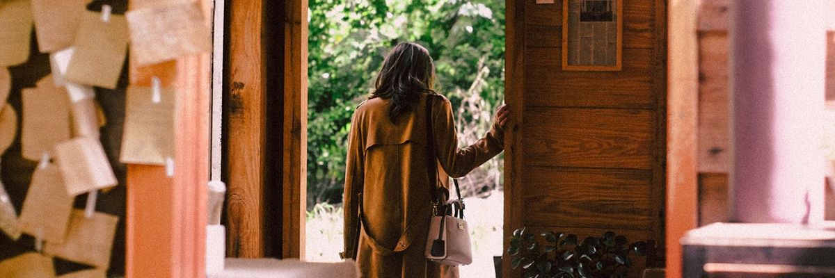 woman standing at the door with her handbag over her shoulder