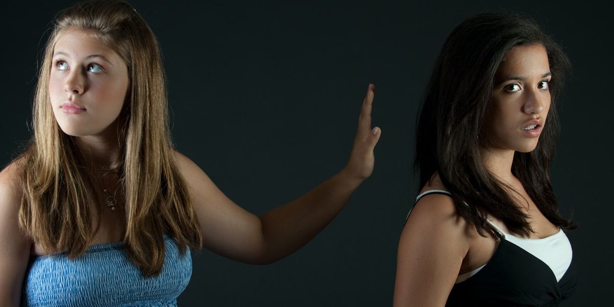One woman refuses to look another in the face, so she puts her hand up between them