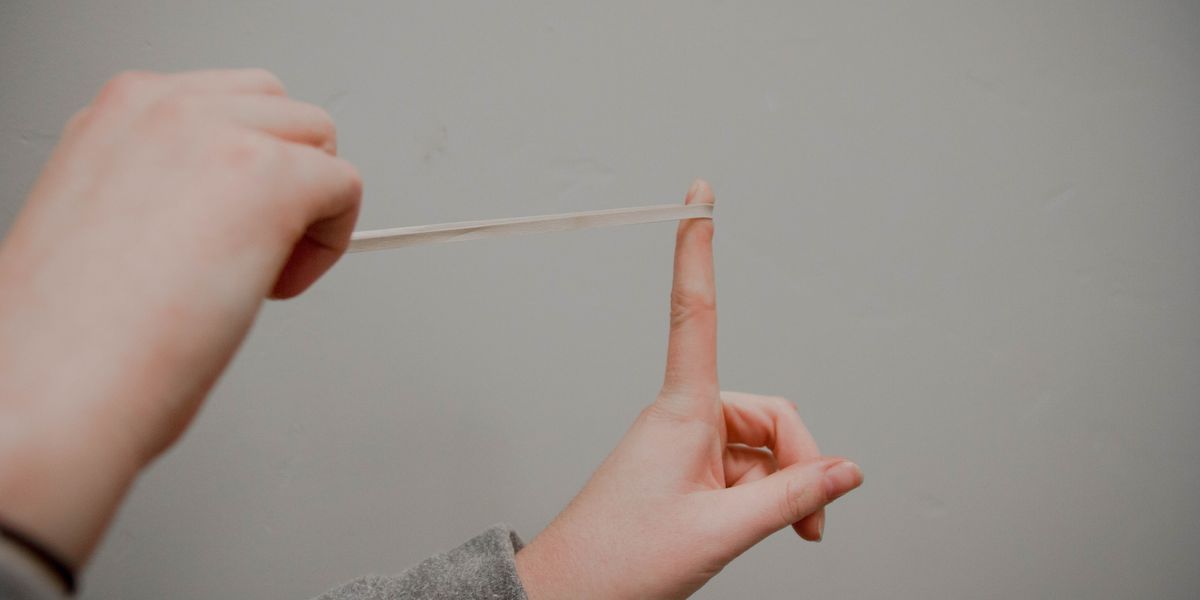 Person about to fling stretched rubber band