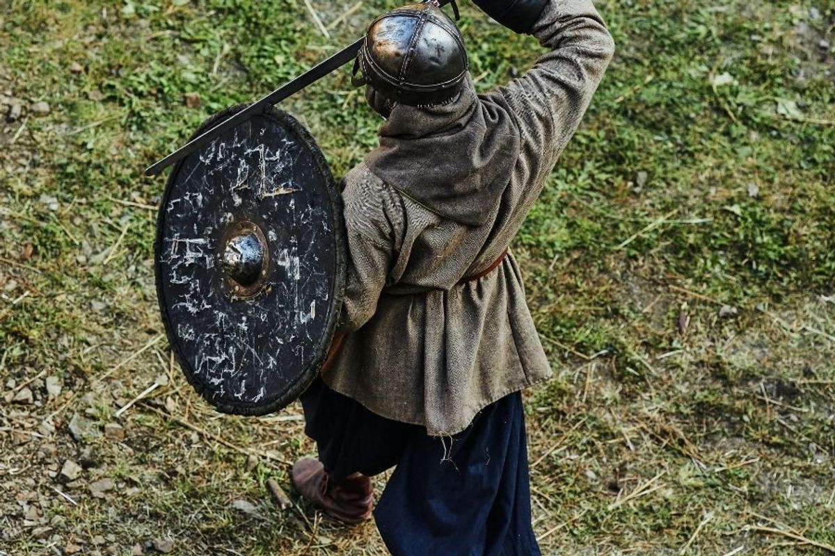 man in medieval garb holding a sword and shield